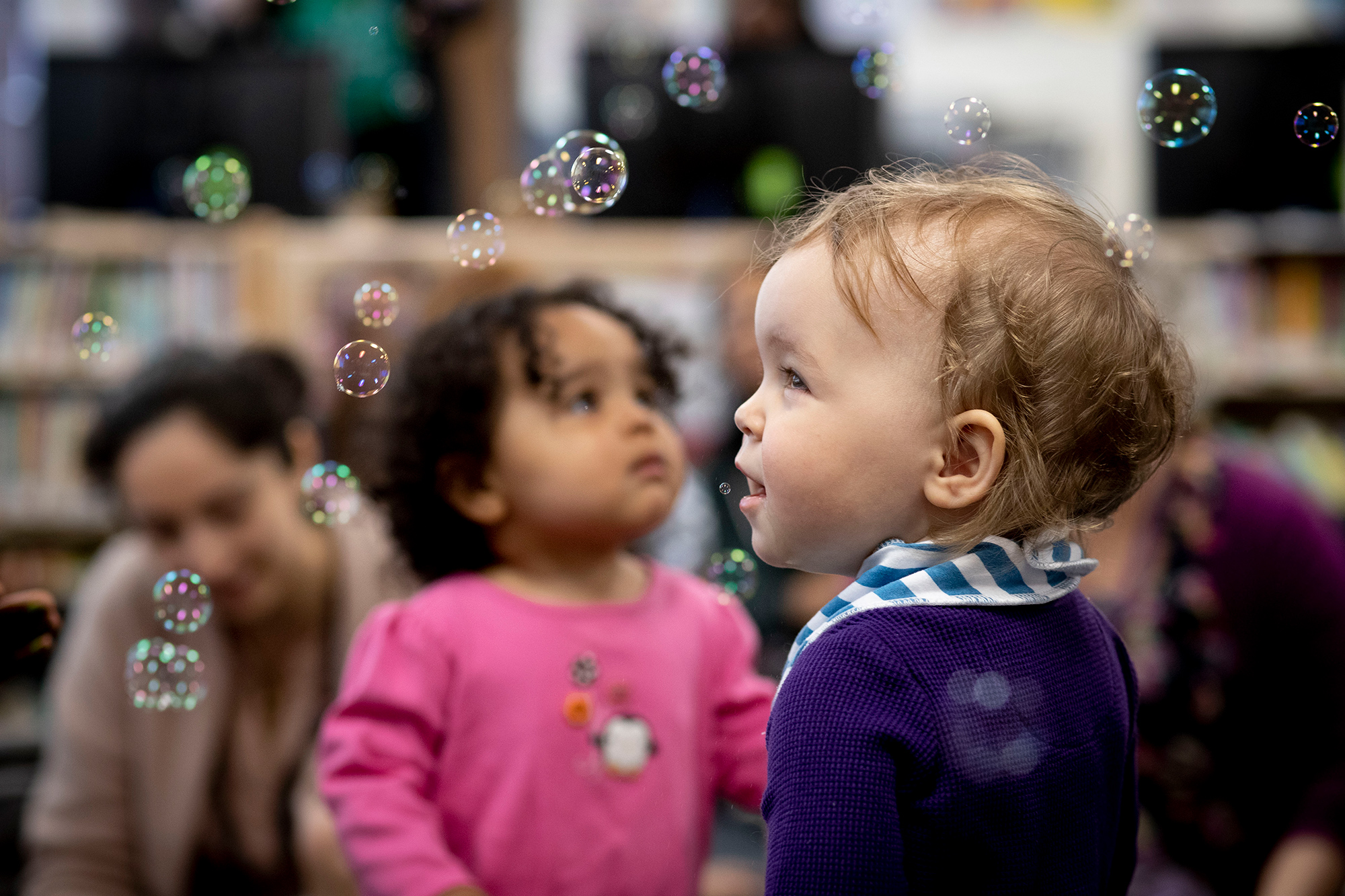 A child watches the bubbles being blown around the room. Photo by Ryan Brandenberg.