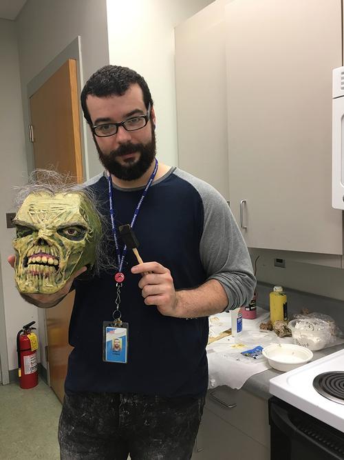 Joseph Torres, LA at Fumo Family Library, with his zombie, created with cardboard, glue ,and hair from an old prop wig.