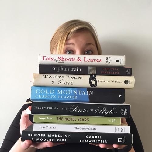 The author under a pile of books she hasn't read.