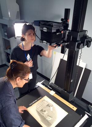 Brittney and Meg digitizing the Charles Henry Sykes political cartoons in our Collection Care department.