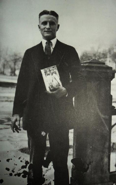 F. Scott Fitzgerald holding a copy of <i>The Great Gatsby</i>