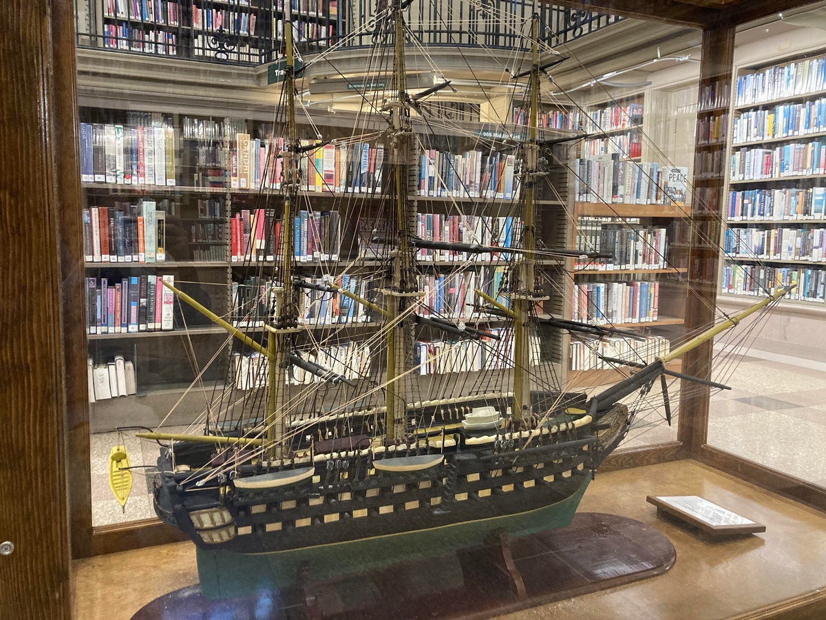 Model of the North Carolina displayed between browsing shelves in Parkway Central's Social Science and History Department.