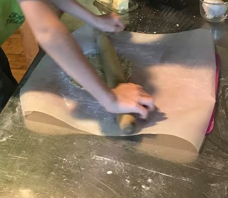 rolling a dough ball onto a sheet