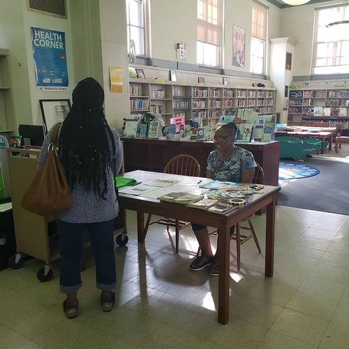 Pat Erwin-Blue, a Resident Consultant Team member, talking to a visitor at Paschalville Library.