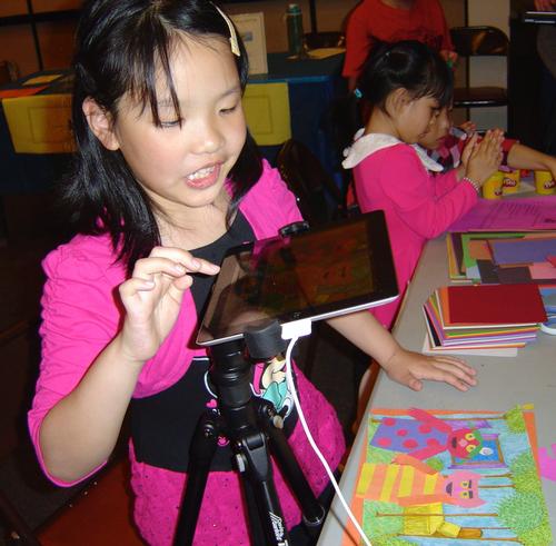 A young attendee uses an iPad to create images for stop motion animation.