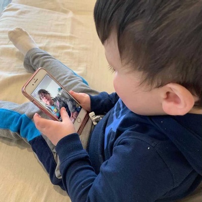 A young patron watches Virtual Baby Storytime with their favorite librarian