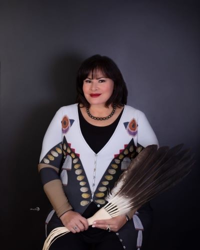 headshot of woman holding feather fan object